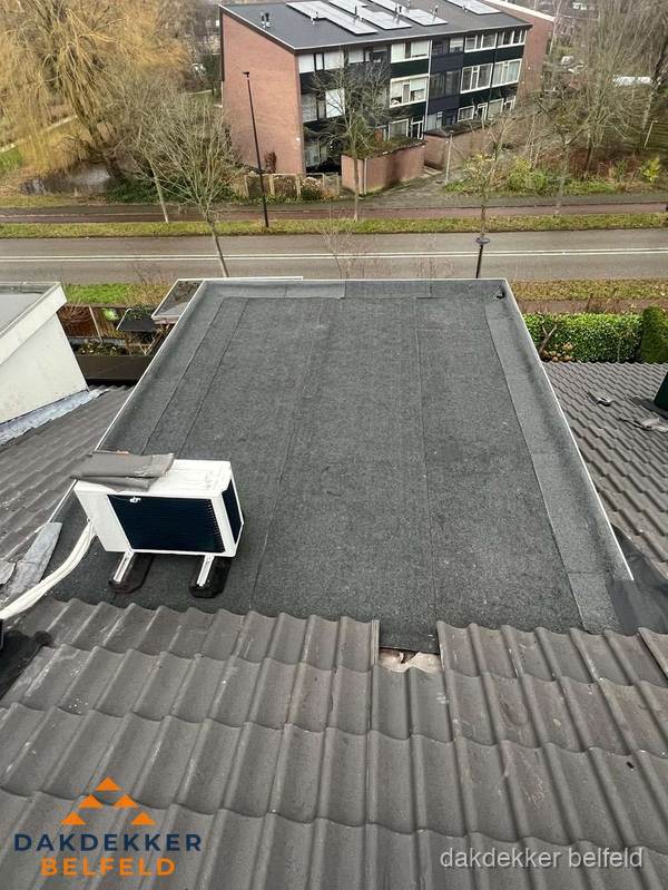 Plat dak inspectie met bitumen bedekking naast schuin pannendak in Belfeld Plat dak inspectie met bitumen bedekking naast schuin pannendak in Belfeld