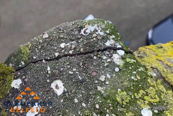 Beschadigde en verweerde nokvorst met scheuren en mos in Belfeld Beschadigde en verweerde nokvorst met scheuren en mos in Belfeld