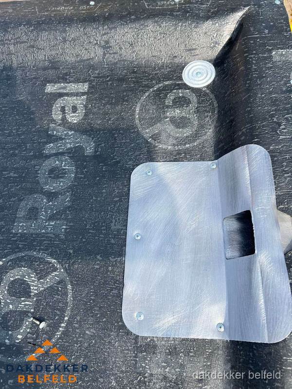 Dakdoorvoer met metalen afvoerplaat op bitumen dak in Belfeld