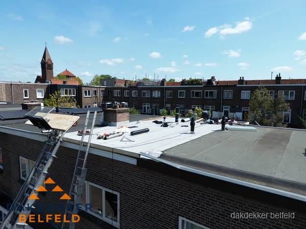 Dakdekkers aan het werk op plat dak in Belfeld