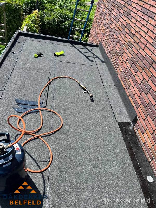 Plat dak met bitumen en brandgereedschap van dakdekkersbedrijf in Belfeld Plat dak met bitumen en brandgereedschap van dakdekkersbedrijf in Belfeld