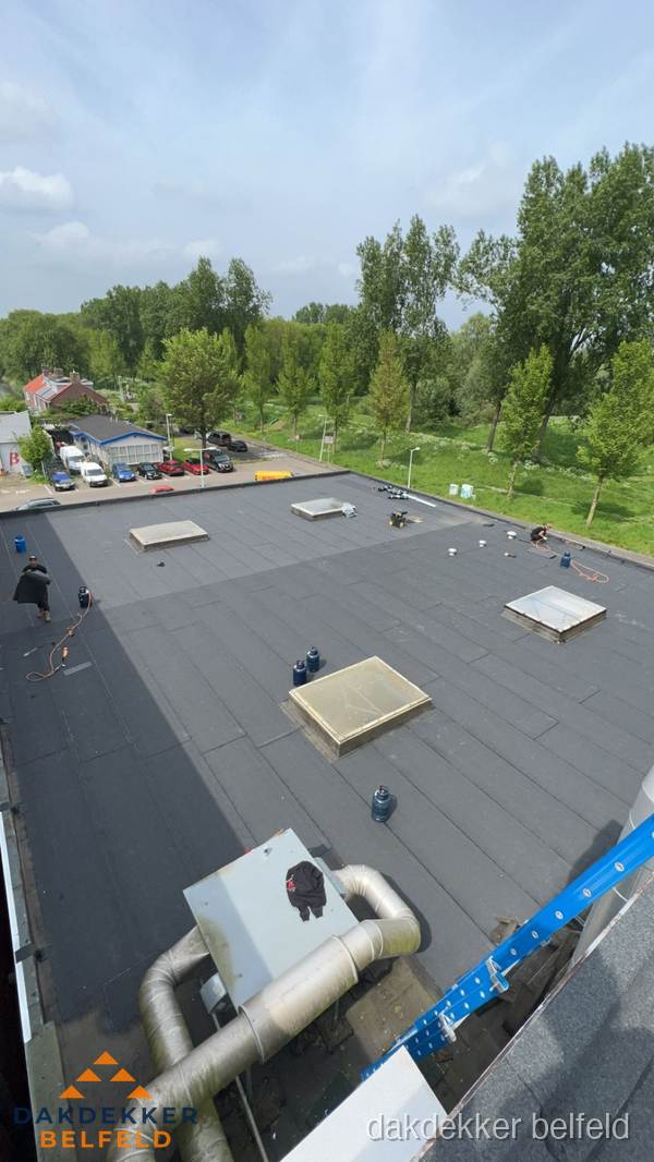 Dakdekker aan het werk op groot plat dak met bitumen in Belfeld Dakdekker aan het werk op groot plat dak met bitumen in Belfeld