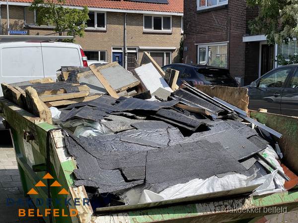 Afvalcontainer met gesloopt dakmateriaal tijdens dakkapel renovatie in Belfeld Afvalcontainer met gesloopt dakmateriaal tijdens dakkapel renovatie in Belfeld