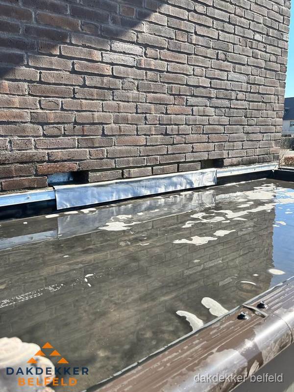 Stilstaand water op plat dak door slechte afwatering in Belfeld Stilstaand water op plat dak door slechte afwatering in Belfeld