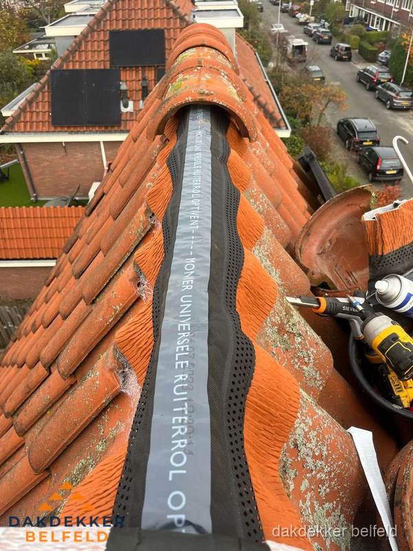 Dakdekker vervangt nokvorst met ruiterrol op pannendak in Belfeld Dakdekker vervangt nokvorst met ruiterrol op pannendak in Belfeld