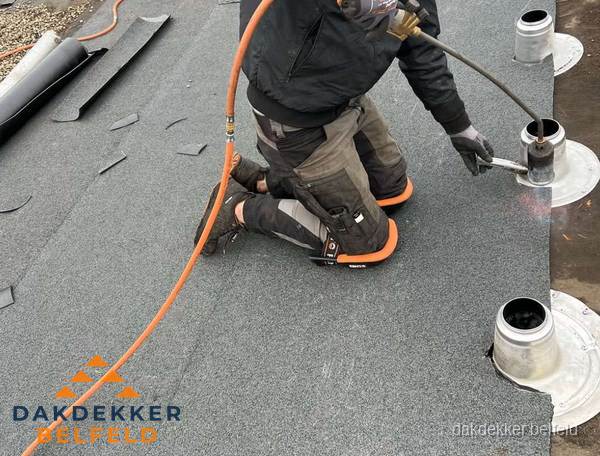 Dakdekker repareert bitumen dakleer bij dakdoorvoer in Belfeld Dakdekker repareert bitumen dakleer bij dakdoorvoer in Belfeld