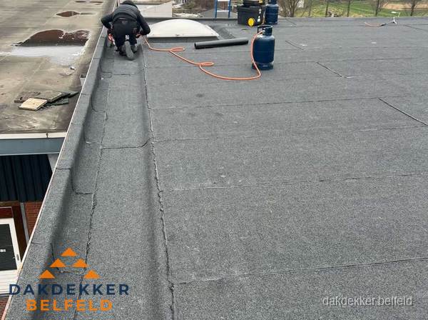 Dakdekker repareert bitumen dakbedekking op groot plat dak in Belfeld Dakdekker repareert bitumen dakbedekking op groot plat dak in Belfeld